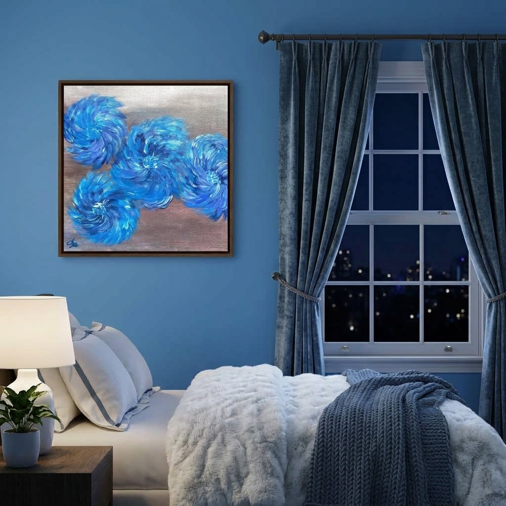 A framed abstract painting with swirling blue brushstrokes on a textured beige background, hanging on a blue wall above a bed in a styled bedroom with gray curtains and a nightstand lamp.